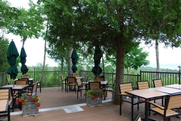 Tree-shaded patio seating with flower planters at Ember Restaurant in Door County
