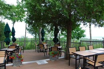 Tree-shaded patio seating with flower planters at Ember Restaurant in Door County